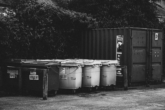 black and white image of large outdoor garbage cans